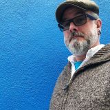portrait-happy-man-wearing-sunglasses-against-blue-sea (1)